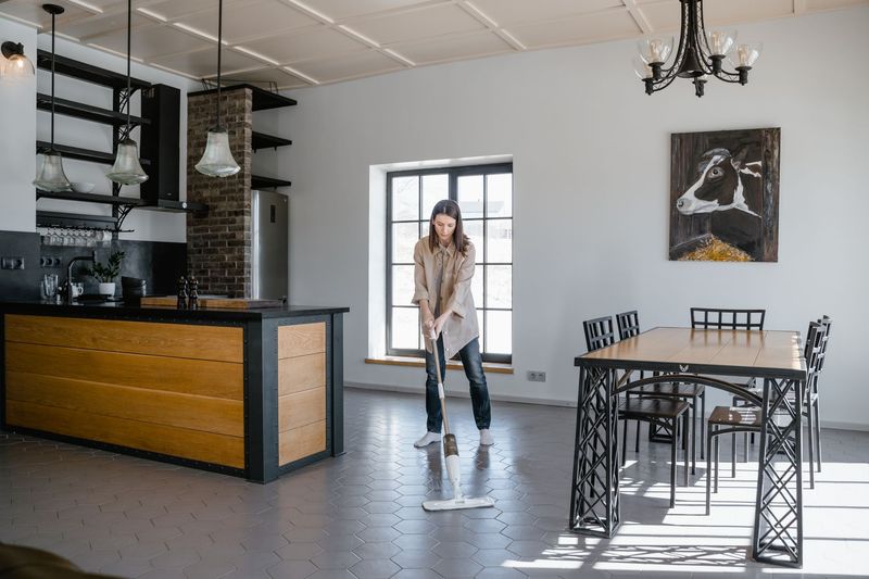 Cleaner carefully wiping kitchen counters during a residential cleaning visit